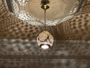 Sphere-shaped chandelier showcasing detailed brass craftsmanship and warm lighting.