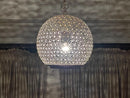 Close-up of the brass pendant light's top, revealing its detailed craftsmanship and unique design.