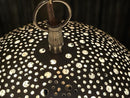 Elegant Moroccan brass pendant light illuminating a stylish interior with warm, inviting light.