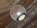 Artisan brass pendant light casting intricate patterns on the ceiling, showcasing its unique design.