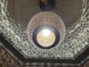 Intricate design of the handcrafted brass pendant light, creating beautiful shadows on the wall.